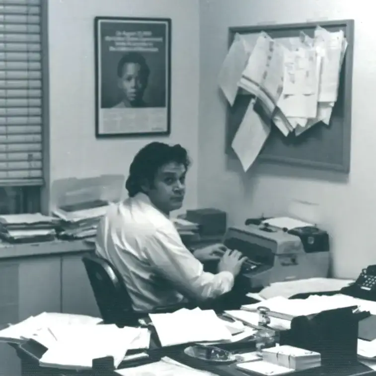 Black-and-white photo of Melvyn Leventhal sitting at his desk typing on a typewriter.